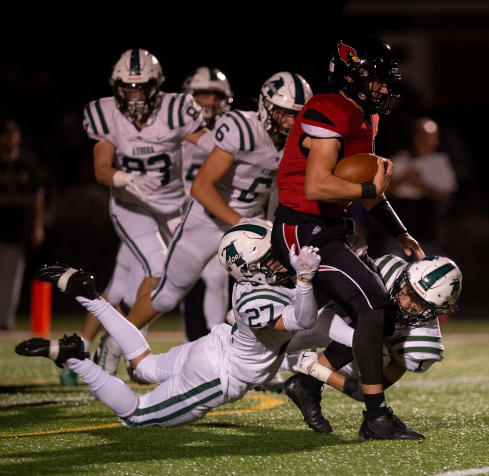 Armen Perez and Dylan Crasi work to bring down Canfield quarterback Broc Lowry.