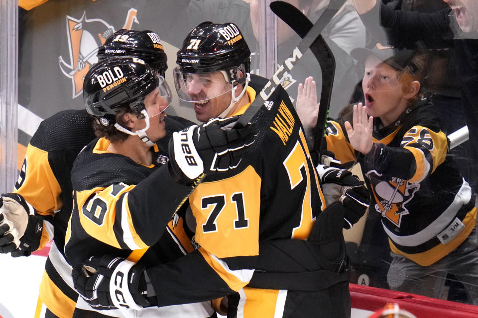 Pittsburgh Penguins' Evgeni Malkin (71) celebrates his goal against the Calgary Flames with Rickard Rakell (67) during the third period of an NHL hockey game in Pittsburgh, Saturday, Oct. 14, 2023. (AP Photo/Gene J. Puskar)