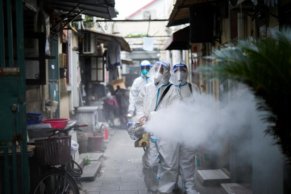 Workers in protective suits disinfect an old residential area under lockdown in Shanghai on April 15.