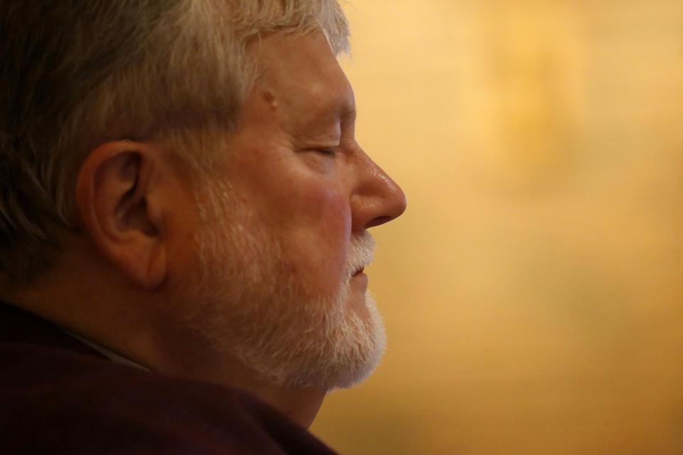 In this Sunday, Dec. 1, 2019 photo, Rev. Philip Schmitter meditates before preparing for a celebration of Mass at Christ the King Catholic Church in Flint, Mich. Schmitter, 74, says that meditating in the morning and evening has helped keep him calmer and has even lowered his blood pressure. He has served the beleaguered city of Flint for 50 years, often inserting himself into social justice issues, including those related to race, environment and poverty. (AP Photo/Martha Irvine)