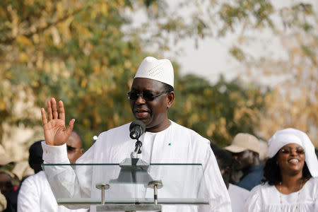 Senegal's President and a candidate for the upcoming presidential elections Macky Sall, speaks after casting his vote at a polling station as his wife Marem Faye Sall stands behind in Fatick, Senegal February 24, 2019. REUTERS/Zohra Bensemra