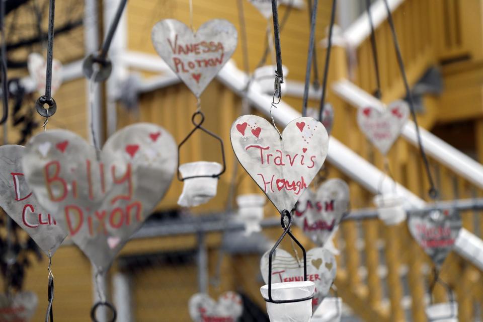 Names of the victims of a warehouse fire hang from an art installation in front of the building Tuesday, Dec. 13, 2016, in Oakland , Calif. The fire killed dozens of people during a electronic dance party as it raced through the building, in the deadliest structure fire in the U.S. in more than a decade. (AP Photo/Marcio Jose Sanchez)