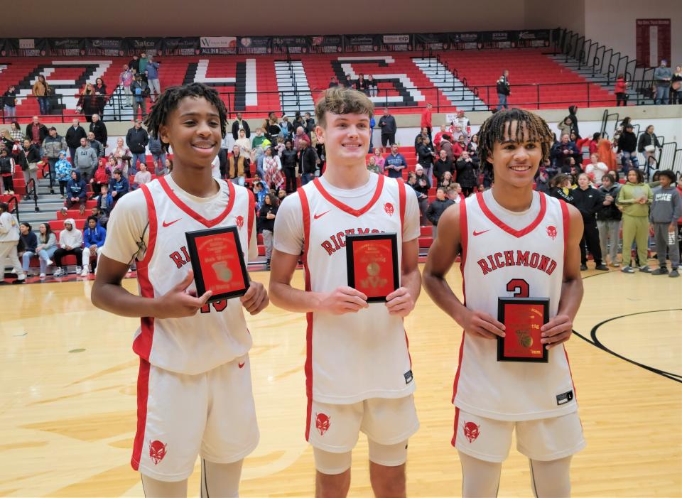 Richmond junior Ryder Cate (center) and sophomores Cedric Horton (left) and Mason Carpenter (right) pose with their All-Wettig Team plaques after leading the Red Devils to the tournament title Dec. 28, 2022.