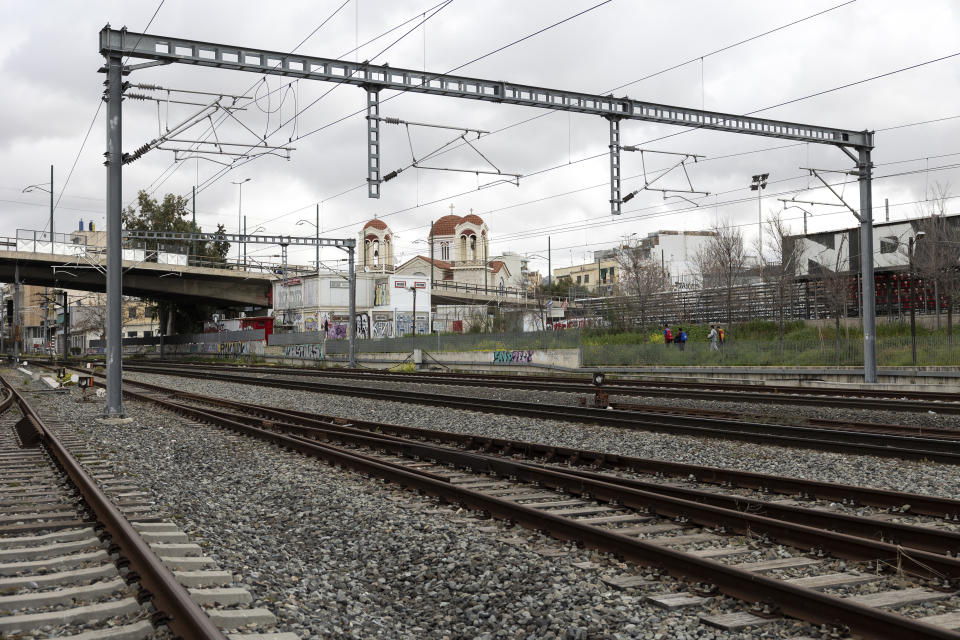 Youth make their way alongside rail lines during a strike, in Athens, Saturday, March 4, 2023. The strike, on its third day, was called by railway workers' associations following an accident where over 50 people died when a passenger train slammed into a freight carrier just before midnight Tuesday in central Greece. (AP Photo/Yorgos Karahalis)