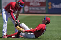 Philadelphia Phillies first baseman Rhys Hoskins (17) falls backwards after hurting his leg fielding a ground ball by Detroit Tigers' Austin Meadows during the second inning of a spring training baseball game Thursday, March 23, 2023, in Clearwater, Fla. Looking on is second base Bryson Stott. Hoskins had to be carted off the field. (AP Photo/Chris O'Meara)