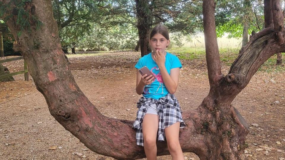 Bethany è seduta sul ramo di un albero