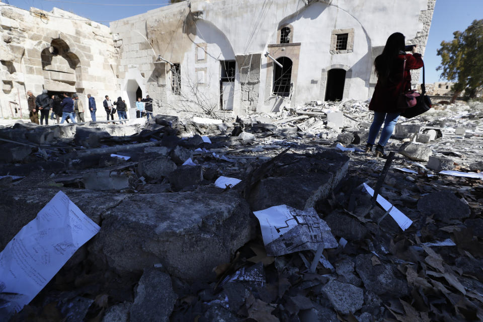 Syrian inspect the damage of a medieval citadel in central Damascus and an applied arts institute house after an early morning Israeli airstrike in the capital city of Damascus, Syria, Sunday, Feb. 19, 2023. Syrian state news reported that Israeli airstrikes have targeted a residential neighborhood in central Damascus. (AP Photo/Omar Sanadiki)