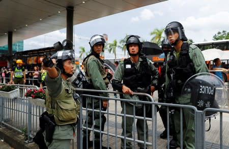 Riot police gather outside the terminals at Hong Kong International Airport