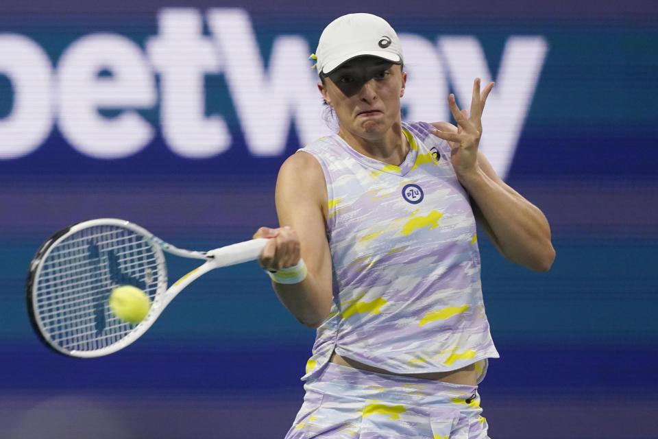 Iga Swiatek, of Poland, returns the ball to Viktorija Golubic, of Switzerland, during the Miami Open tennis tournament, Friday, March 25, 2022, in Miami Gardens, Fla. (AP Photo/Marta Lavandier)