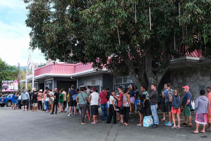 People wait in line to enter a general store that remained open in the Magenta neighborhood of Noumea amid protests related to a debate over a draft constitution to expand the electorate for upcoming elections in the French overseas territory of New Caledonia. More than 130 people were arrested in New Caledonia as violent protests rocked the French archipelago in the Pacific. Theo Rouby/AFP/dpa