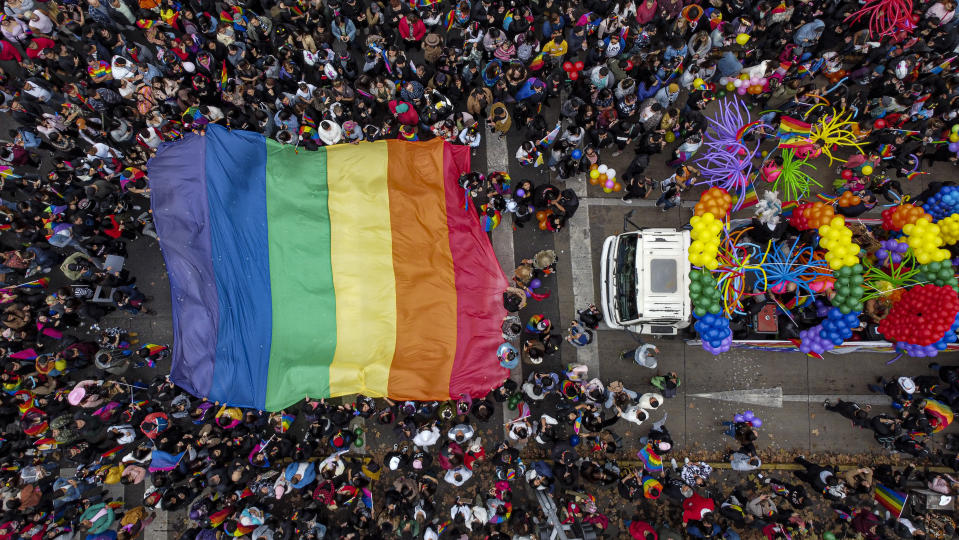 Los participantes ondean la bandera del arcoíris mientras asisten en la marcha anual del Orgullo en Santiago, Chile, el domingo 25 de junio de 2023. (Foto AP/Esteban Félix)