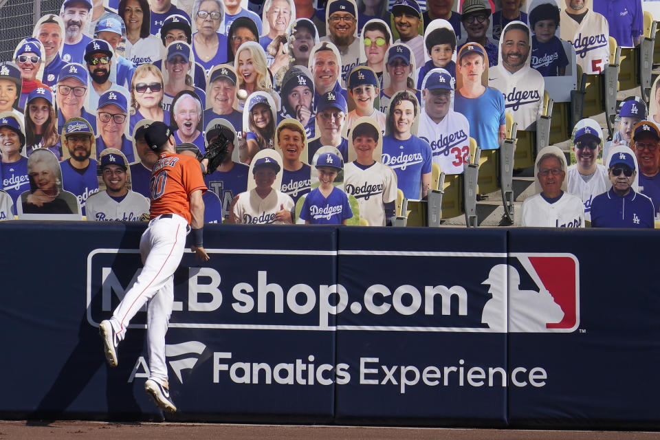 Houston Astros right fielder Kyle Tucker cannot catch a three-run home run hit by Oakland Athletics' Chad Pinder that lands in front of cutouts seated at Dodger Stadium during the seventh inning of Game 3 of a baseball American League Division Series in Los Angeles, Wednesday, Oct. 7, 2020. (AP Photo/Marcio Jose Sanchez)