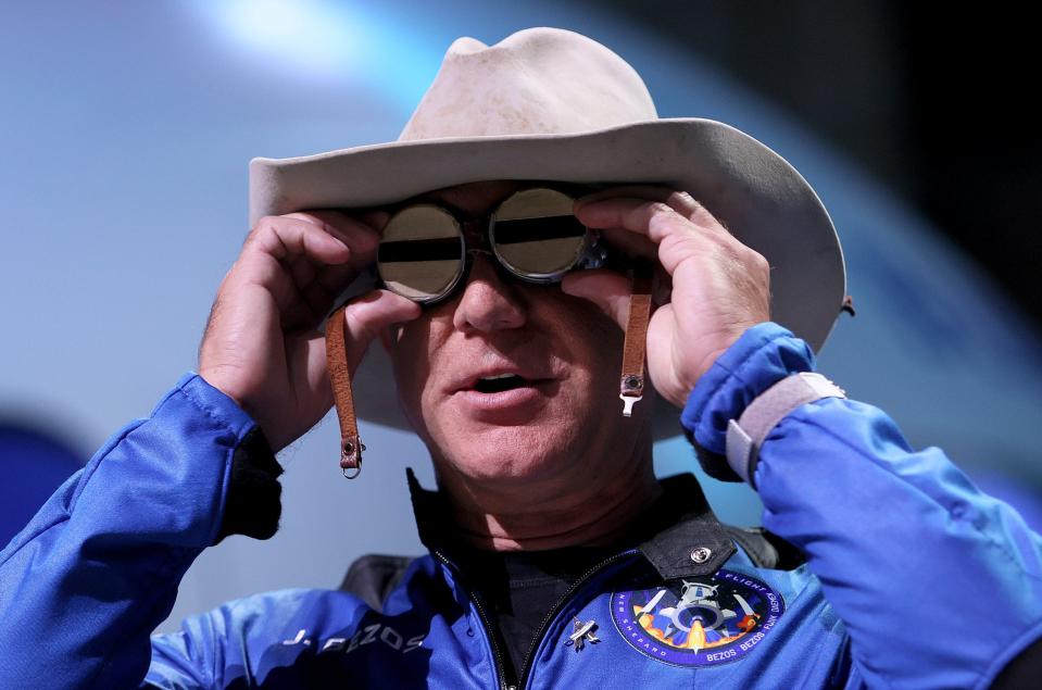 Blue Origin founder Jeff Bezos wears a pair of reflective aviation glasses under a cowboy hat