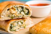 <p>These pizza pockets are filled with gooey, cheesy goodness and don't even require making a dough by hand. Just pick up a tube of pre-made French bread dough, and you'll be on your way to calzone heaven.</p><p>Get the <strong><a href="https://www.delish.com/cooking/recipe-ideas/recipes/a47164/mini-cheesy-chicken-calzones-recipe/" rel="nofollow noopener" target="_blank" data-ylk="slk:Mini Cheesy Chicken Calzones recipe;elm:context_link;itc:0;sec:content-canvas" class="link ">Mini Cheesy Chicken Calzones recipe</a></strong>. </p>