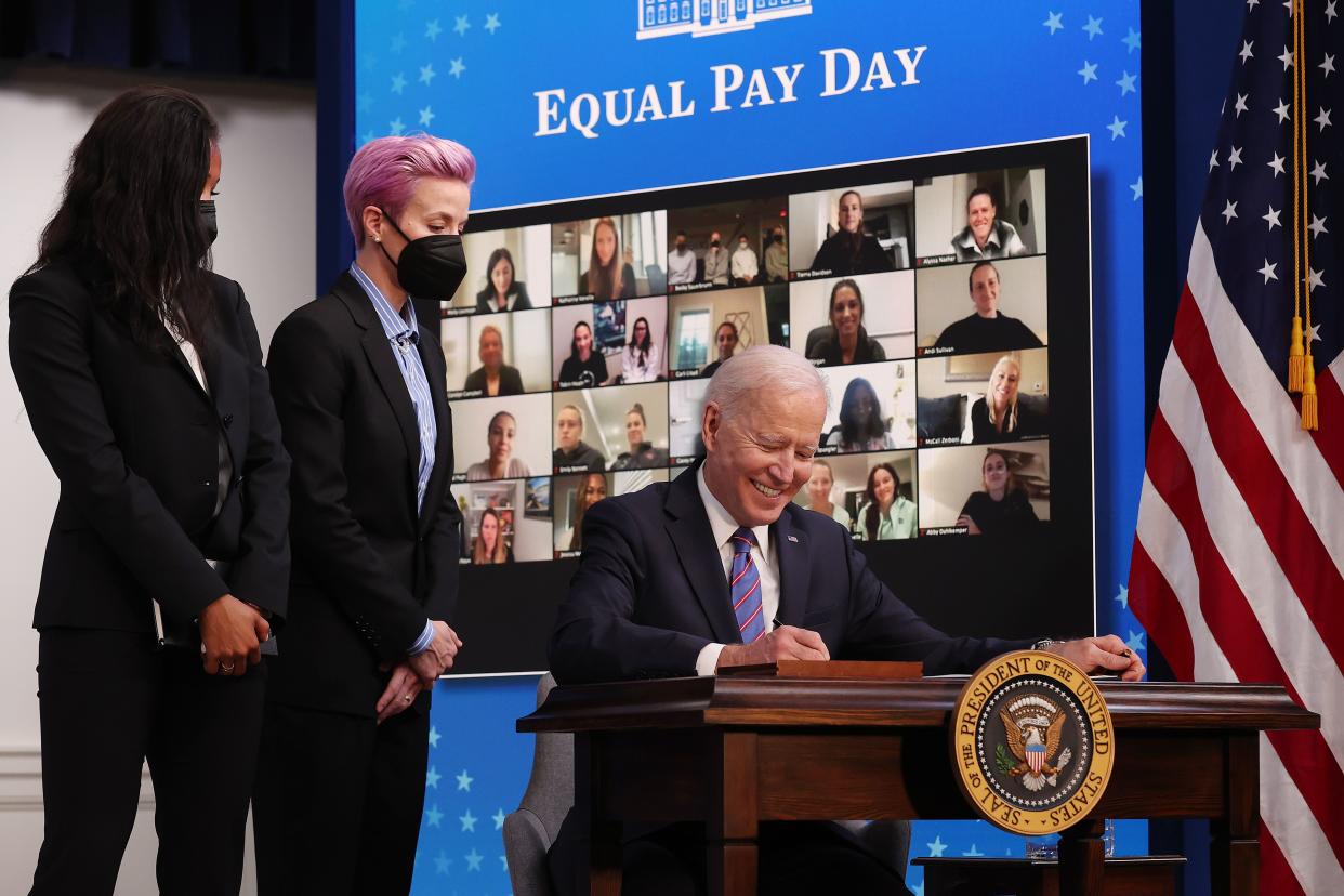 U.S. President Joe Biden signs a proclamation to mark Equal Pay Day with soccer superstars Margaret Purce (L) and Megan Rapinoe, with members of the U.S. Soccer Women’s National Team joining virtually, in the South Court Auditorium in the Eisenhower Executive Office Building on March 24, 2021, in Washington, DC. Highlighting the gender pay gap, Equal Pay Day raises awareness that women in the United States earned $0.82 for every dollar men earned in 2019, according to the National Committee on Pay Equity.