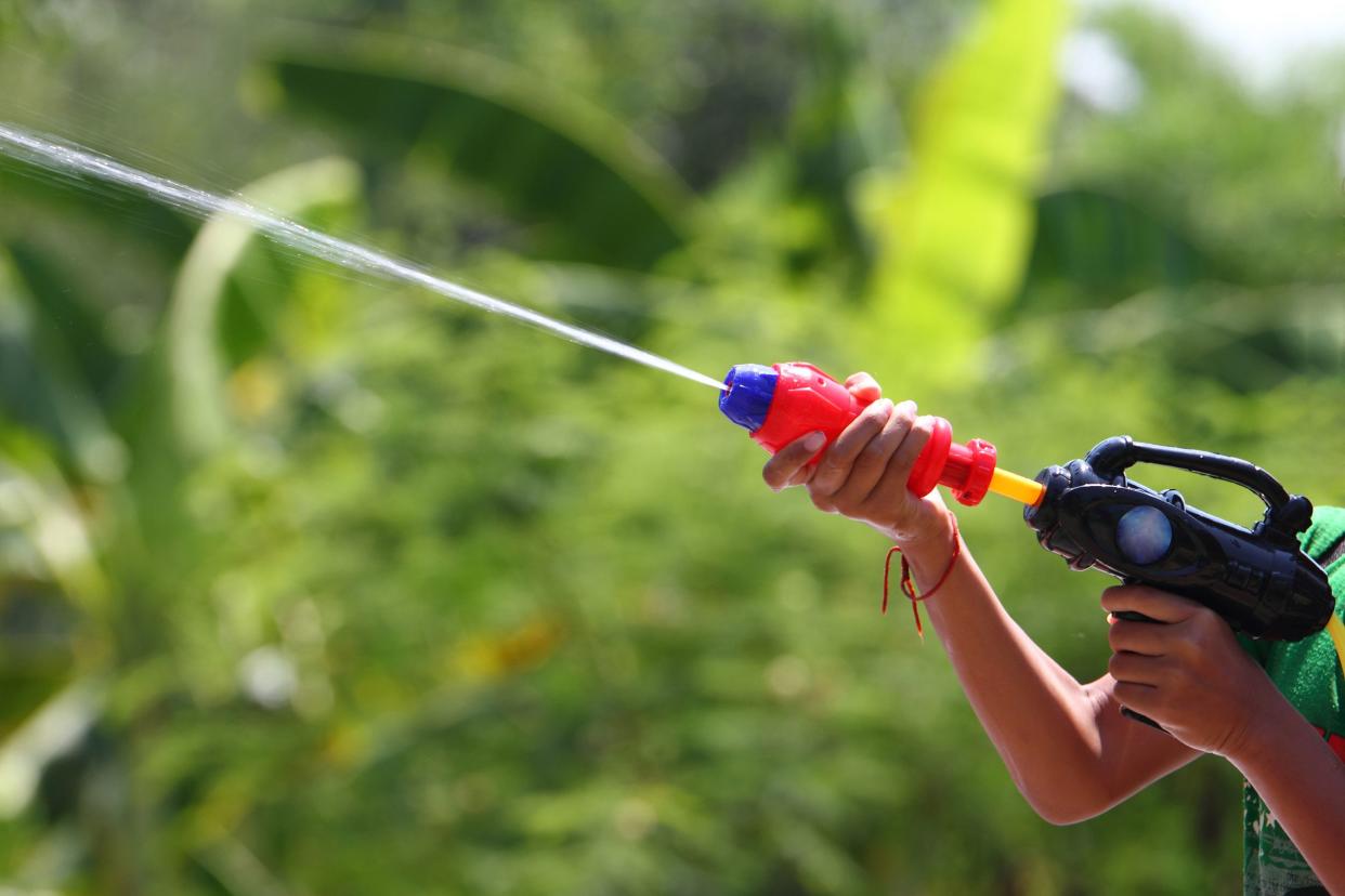 boy shooting water gun outside