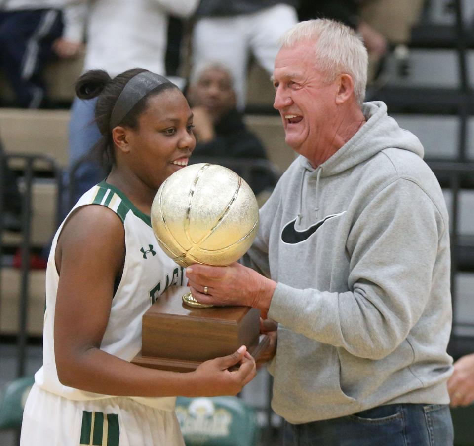 GlenOak's Dai'Shona Polk receives the Federal League championship trophy from Federal League commissioner Joe Eaton after the Golden Eagles' victory over Hoover on Wednesday, February 8, 2017 in Plain Twp.
