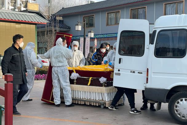 PHOTO: Workers in protective suits transfer a body in a casket at a funeral home, amid the COVID-19 outbreak in Beijing, China, on Dec. 17, 2022. (Alessandro Diviggiano/Reuters)