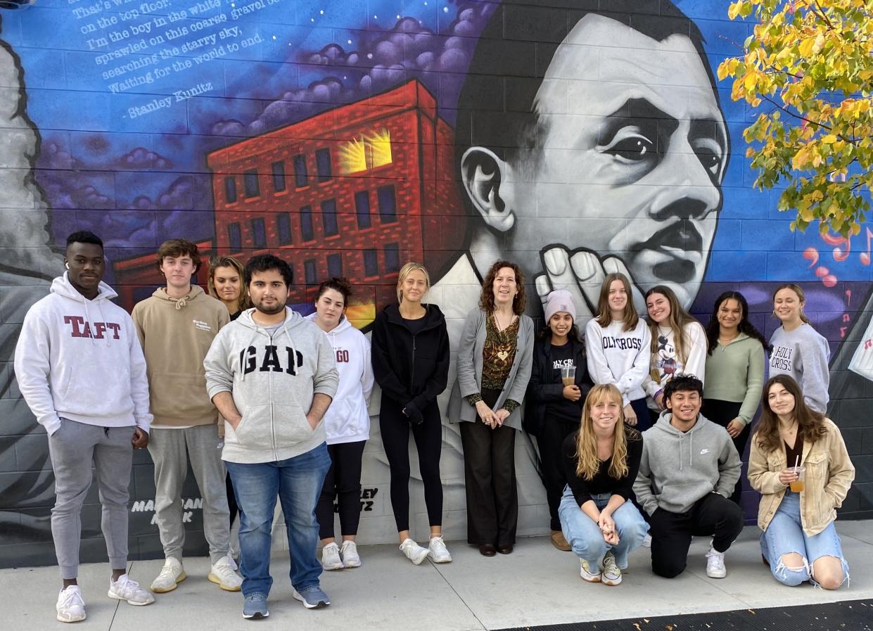 College of the Holy Cross Professor Susan Elizabeth Sweeney, center, stands with students in Sweeney's poetry and poetics class in front of an image of Stanley Kunitz, part of the Ash Street mural, in October 2022. The group took the driving tour dedicated to Kunitz, as part of the Mapping Worcester in Poetry project. The tour was followed by a special tour of Kunitz's former home at 4 Woodford St.