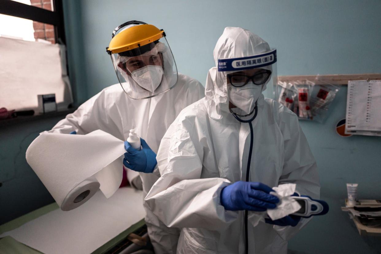 Le docteur Andrea Dotta et sa collègue Marta Castagnotto désinfectent les outils médicaux après avoir rendu visite à des patients infectés ou présentant des symptômes de Covid-19 à la clinique Usca de l'hôpital San Lazzaro en Italie, le 28 décembre 2020. (Photo d'illustration) - Marco Bertorello - AFP