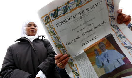 FILE PHOTO: Nuns read the Vatican newspaper L'Osservatore Romano before newly elected Pope Francis appears at the window of his future private apartment to bless the faithful, gathered below in St. Peter's Square, during the Sunday Angelus prayer at the Vatican March 17, 2013. REUTERS/Max Rossi/File Photo