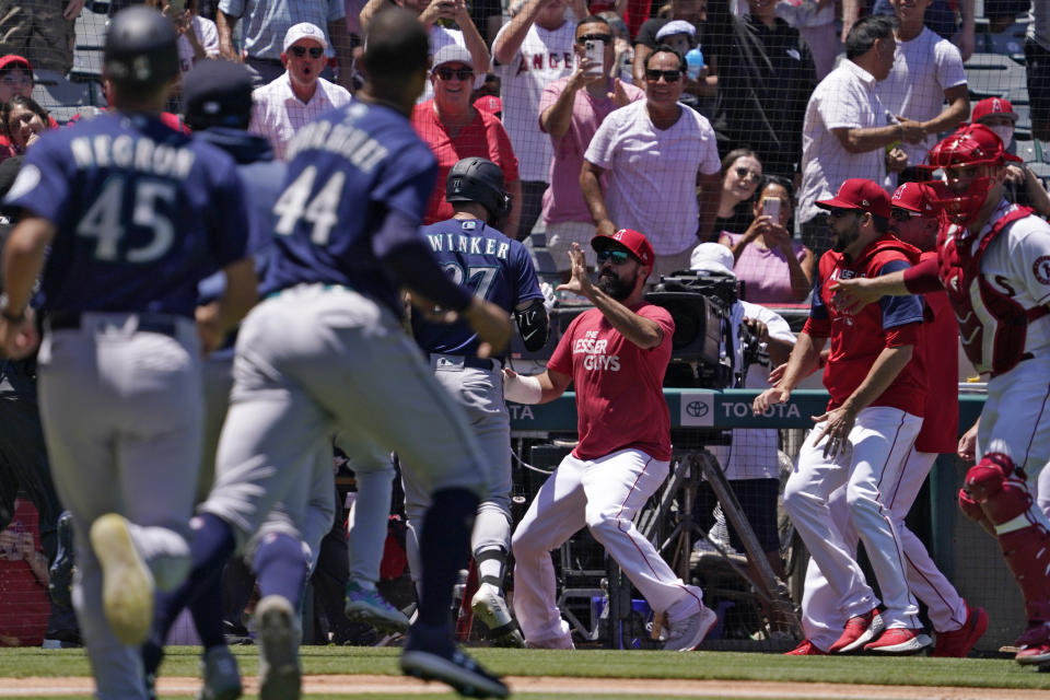 Seattle Mariners' Jesse Winker, center left, fights with Los Angeles Angels Anthony Rendon, center, right, after he took a close pitch and went after players in the Angels dugout during the second inning of a baseball game Sunday, June 26, 2022, in Anaheim, Calif. (AP Photo/Mark J. Terrill)