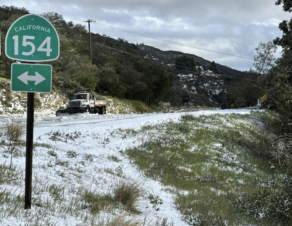 In this photo provided by the Santa Barbara County Fire Department, a snow plow clears snow near the 2,200 ft summit of San Marcos Pass along Highway 154 in Santa Barbara County, Calif., Thursday, Feb. 23, 2023. (Mike Eliason/Santa Barbara County Fire Department via AP)