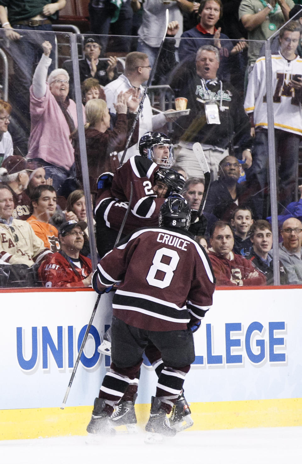 Union's Mike Vecchione, top, leaps into the arms of Sebastien Gingras, center, after scoring a goal with Nick Cruice, bottom, approaching during the third period of an NCAA men's college hockey Frozen Four tournament game against Boston College, Thursday, April 10, 2014, in Philadelphia. Union College won 5-4. (AP Photo/Chris Szagola)