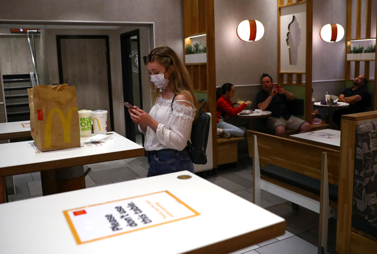 A woman wears a protective face mask in a McDonald's after over 700 restaurants of the fast-food chain reopened with a dine-in service as business restrictions imposed to combat coronavirus disease (COVID-19) pandemic eased, in London, Britain July 22, 2020. REUTERS/Hannah McKay