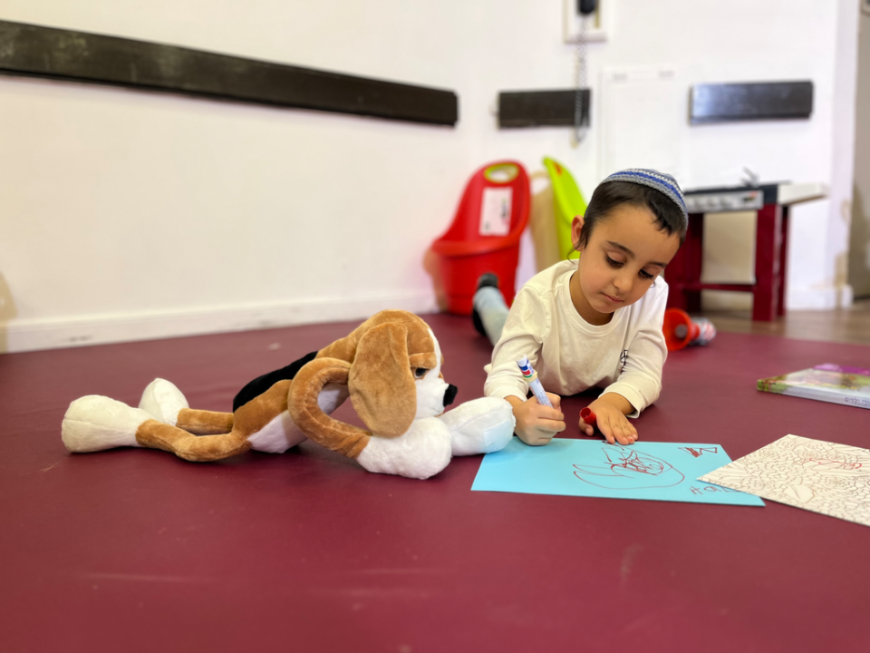 A traumatized young boy from the Israeli city of Sderot uses his Hibuki therapy doll as part of JDC's wide-reaching mental health services for tens of thousands of severely traumatized children who have been impacted by the Oct. 7 attacks and ongoing war.