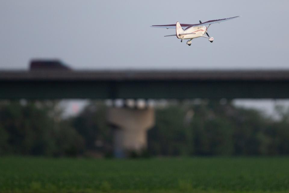 Rich Carpenter's Stinson Reliant flies south toward the Saudou Avenue bridge in North Topeka after taking off from the FAE airstrip.