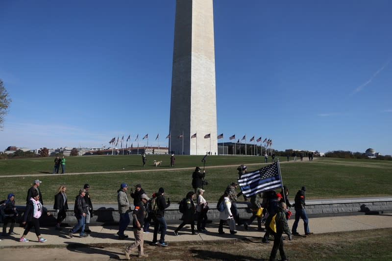 Militia members and pro-gun rights activists participating in the "Declaration of Restoration" rally march pass the Washington Monument in Washington, D.C.