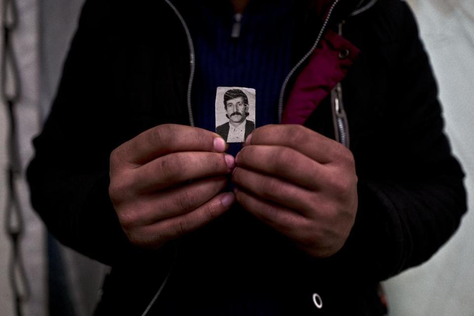 In this Wednesday, Jan. 18, 2017 photo, Dilgash Hassan, 31, a Syrian refugee from al-Hasaka, holds a photograph of his father Khalil when he was younger, at Frakapor refugee camp on the outskirts of the northern Greek city of Thessaloniki. "I have been carrying this picture for the last ten years, it is a holy picture for me, my father is my role model." Dilgash said. (AP Photo/Muhammed Muheisen)