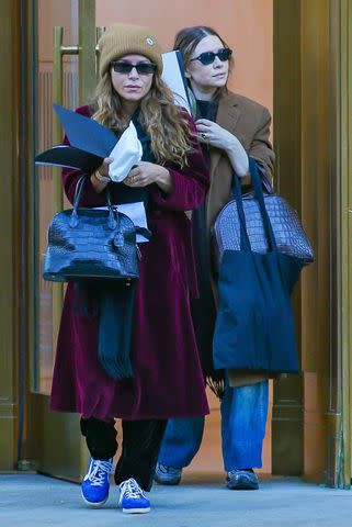 <p>BACKGRID</p> Mary-Kate Olsen and Ashley Olsen pictured leaving a building in New York City on Thursday