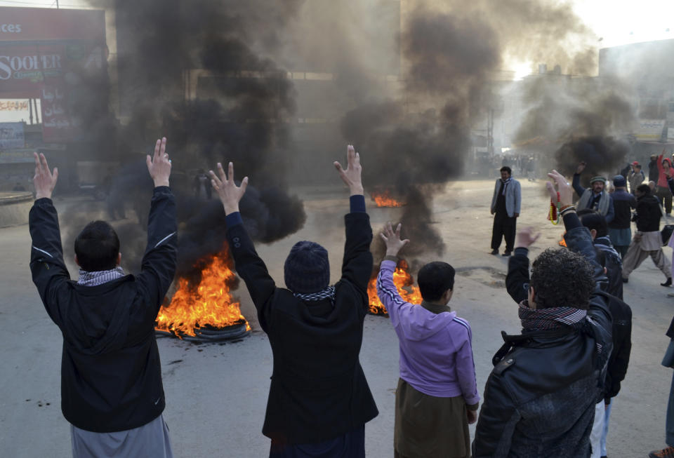 Pakistani Muslim Shiites chant slogans and burn tires, during a protest in Quetta, Pakistan, Wednesday, Jan. 22, 2014. Shiite Muslims in Baluchistan protested Wednesday in Quetta, the capital of Baluchistan, demanding action to stop the continued violence against their sect; they brought the coffins of many of the dead into the streets as part of their protest. (AP Photo/Arshad Butt)