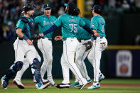 Seattle Mariners relief pitcher Andrés Muñoz (75), catcher Cal Raleight, left, and teammates celebrate a 3-1 win over the Arizona Diamondbacks in a baseball game Saturday, April 27, 2024, in Seattle. (AP Photo/Lindsey Wasson)