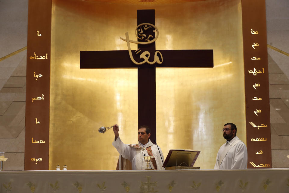 Lebanese priest Marwan Mouawad, center, celebrating during Sunday Mass at Saint Maron-Baouchrieh Church that was damaged by last Tuesday's explosion that hit the Beirut seaport, in Baouchrieh neighborhood in Beirut, Lebanon, Sunday, Aug. 9, 2020.In interviews with The Associated Press, Father Rabih Thoumy and church priest Father Marwan Mouawad recount the horror of the moment the blast rocked the church. Thoumy says: "God has saved us.” (AP Photo/Hussein Malla)