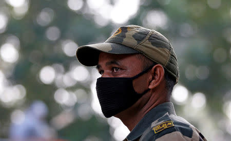 A paramilitary soldier wears a mask as he stands guard on a street near Prime Minister's residence in New Delhi, India November 8, 2016/REUTERS/Adnan Abidi