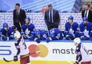 Toronto Maple Leafs coach Sheldon Keefe, back center, and players react as Columbus Blue Jackets centers Boone Jenner (38) and Alexander Wennberg (10) celebrate an empty-net goal during the third period of an NHL hockey playoff game Sunday, Aug. 9, 2020, in Toronto. (Nathan Denette/The Canadian Press via AP)