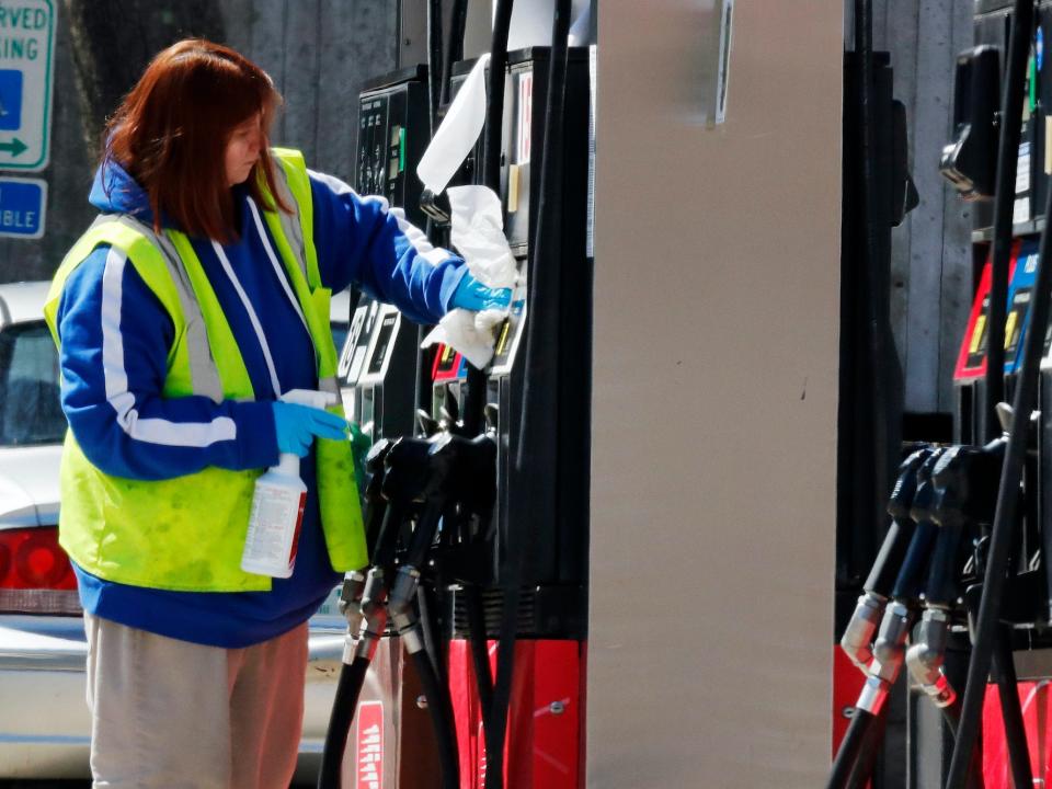A worker cleans and sanitizes a pump at the Speedway gas station in Concord, New Hampshire in March 31, 2020