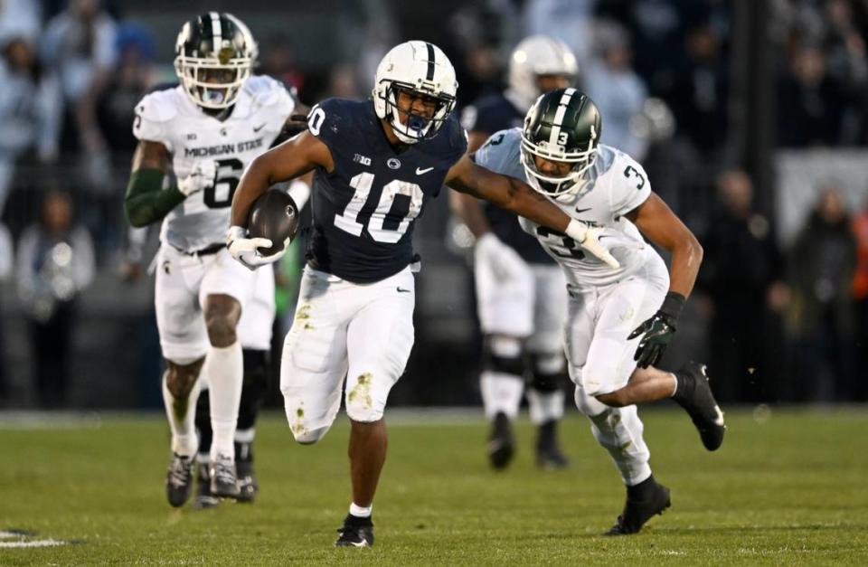 Penn State running back Nick Singleton runs from Michigan State defenders during the game on Saturday, Nov. 26, 2022.