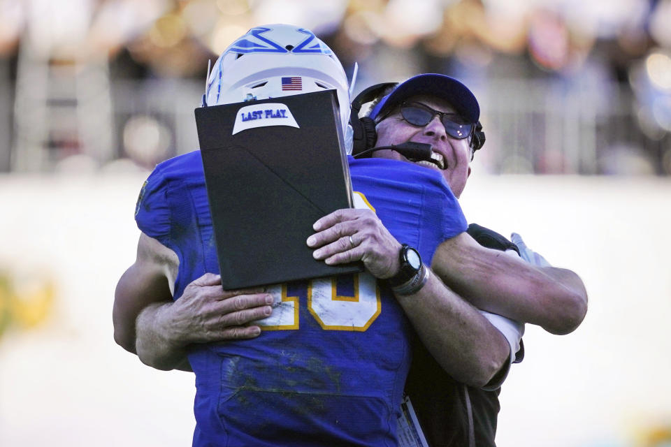 South Dakota State head coach John Stiegelmeier, right, hugs wide receiver Jaxon Janke (10) after he scored during the fourth quarter of the FCS Championship NCAA college football game against North Dakota State, Sunday, Jan. 8, 2023, in Frisco, Texas. South Dakota State won 45-21. (AP Photo/LM Otero)