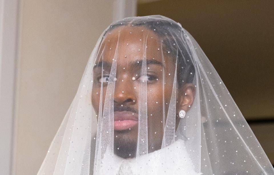 Alton in an elegant bridal outfit with a beaded design and veil