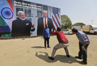 A man stands for a photograph in front of a hoarding welcoming U.S President Donald Trump, at the airport ahead of his visit in Ahmedabad, India, Saturday, Feb. 22, 2020. To welcome Trump, who last year likened Modi to Elvis Presley for his crowd-pulling power at a joint rally the two leaders held in Houston, the Gujarat government has spent almost $14 million on ads blanketing the city that show them holding up their hands, flanked by the Indian and U.S. flags. (AP Photo/Ajit Solanki)