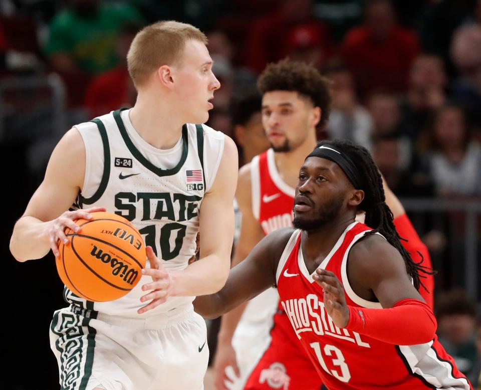 Michigan State Spartans forward Joey Hauser (10) is defended by Ohio State Buckeyes guard Isaac Likekele (13) during the Big Ten Men’s Basketball Tournament game, Friday, March 10, 2023, at United Center in Chicago. 