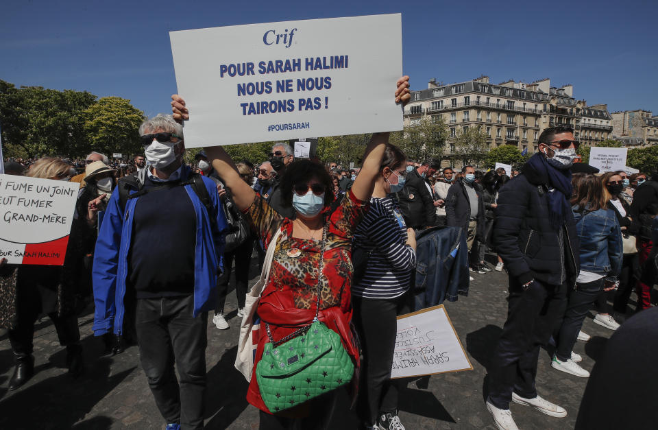 A woman holds a placard that reads, "for Sarah Halimi we won't be quiet," during a protest organized by Jewish associations, who say justice has not been done for the killing of French Jewish woman Sarah Halimi, at Trocadero Plaza near Eiffel Tower in Paris, Sunday, April 25, 2021. Thousands of people have gathered in Paris and other French cities to denounce a ruling by France's highest court that the killer of Jewish woman Sarah Halimi was not criminally responsible and therefore could not go on trial. (AP Photo/Michel Euler)