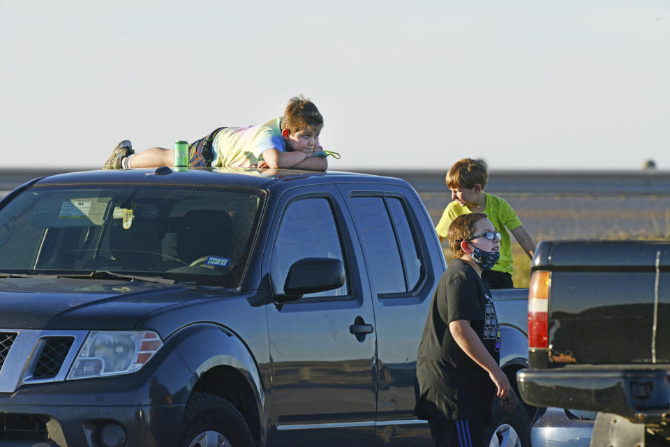 Youngsters wait to see SpaceX's prototype starship take off for a test flight, Wednesday, Dec. 9, 2020, at their Boca Chica, Texas facility. (Miguel Roberts/The Brownsville Herald via AP)