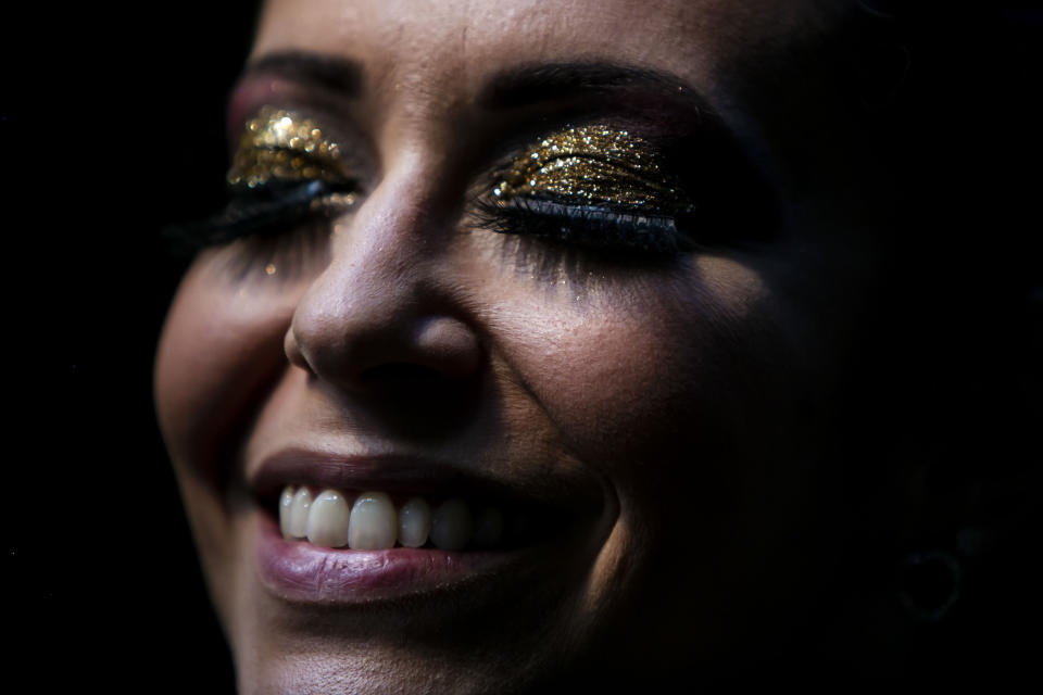 A member of the "Desliga da Justica" street band gets dressed in her costume in Rio de Janeiro, Brazil, Sunday, Feb. 14, 2021. The group's performance was broadcast live on social media for those who were unable to participate in the carnival due to COVID restrictions after the city's government officially suspended Carnival and banned street parades or clandestine parties. (AP Photo/Bruna Prado)