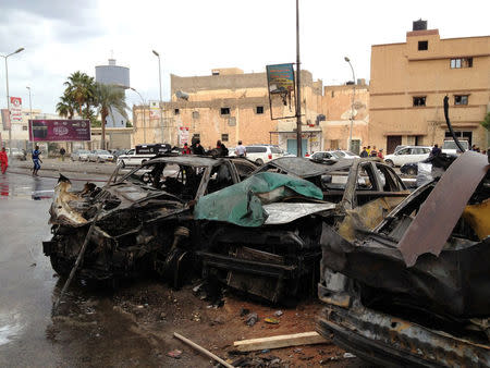 People look at the remnants of a car at the scene of a car bomb in Benghazi, Libya, November 21, 2016. REUTERS/Stringer