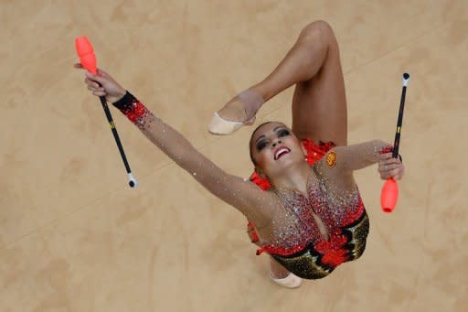 La gimnasta rusa Evgeniya Kanaeva, durante su ejercicio de mazas en la final de este sábado en Londres. Kanaeva mantuvo este sábado su reinado indiscutible sobre la gimnasia rítmica al revalidar su título olímpico de la disciplina en los Juegos de Londres-2012, convirtiéndose en la primera gimnasta que logra esta gesta en este deporte. (AFP | antonin thuillier)